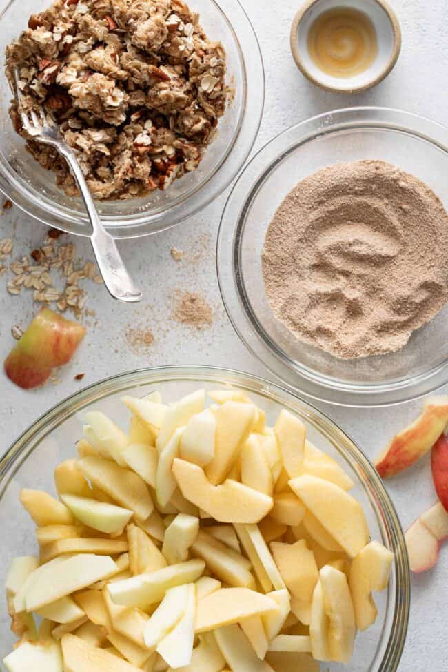 Class mixing bowls filled with oats, sugar and nuts.