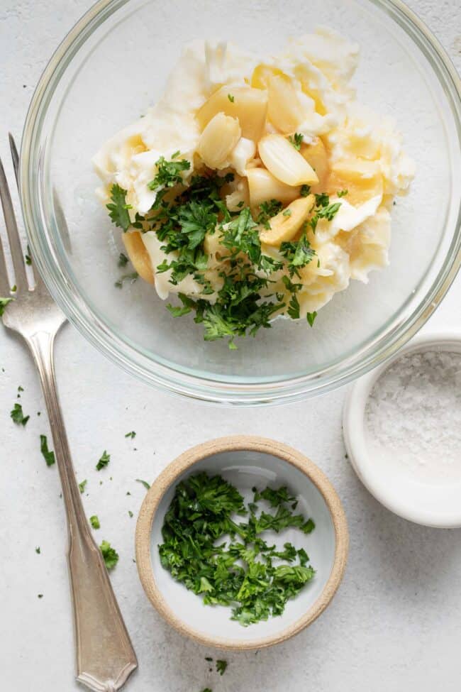 A glass mixing bowl filled with a creamy spread.