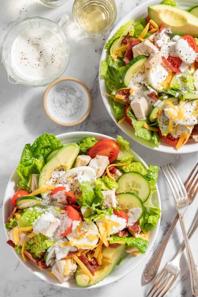 Two white bowls filled with turkey cobb salad.