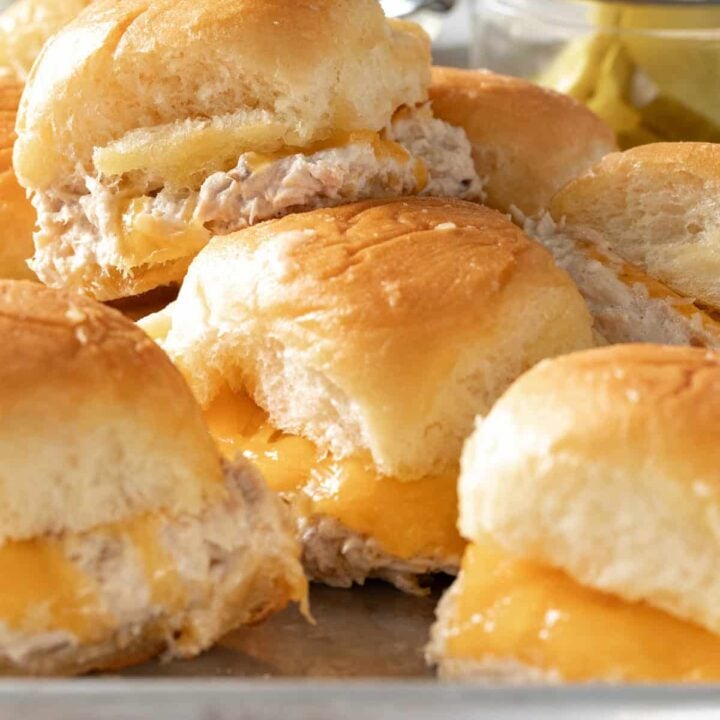 A cookie sheet filled with tuna melt sliders.
