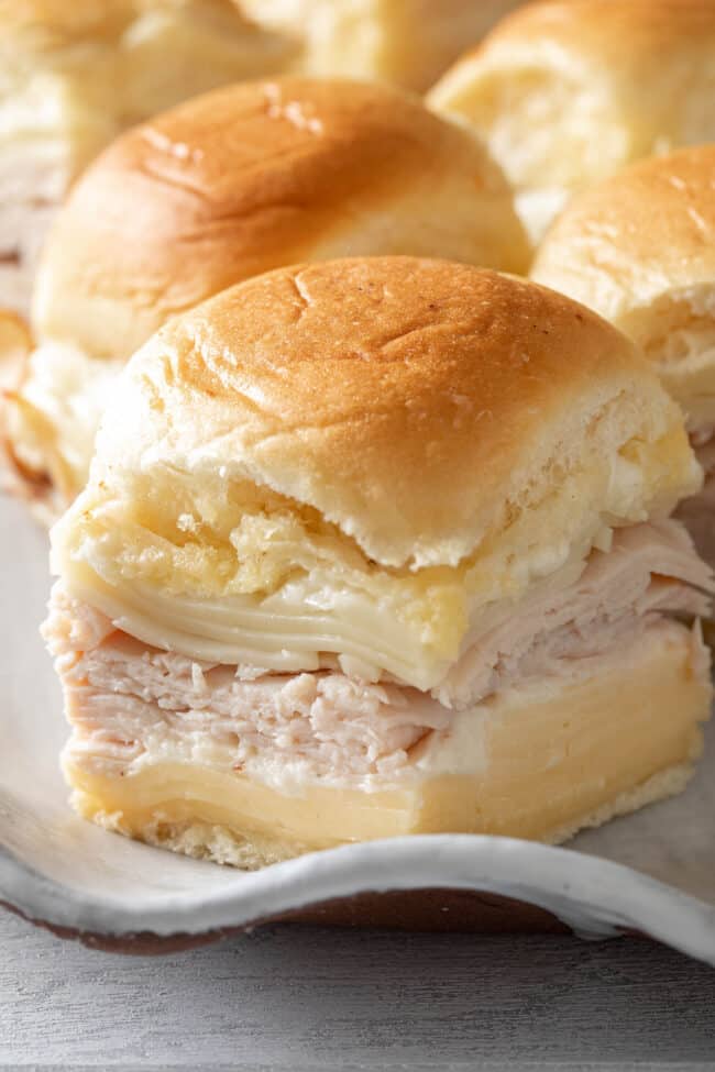 A platter filled with Hawaiian roll turkey sliders.