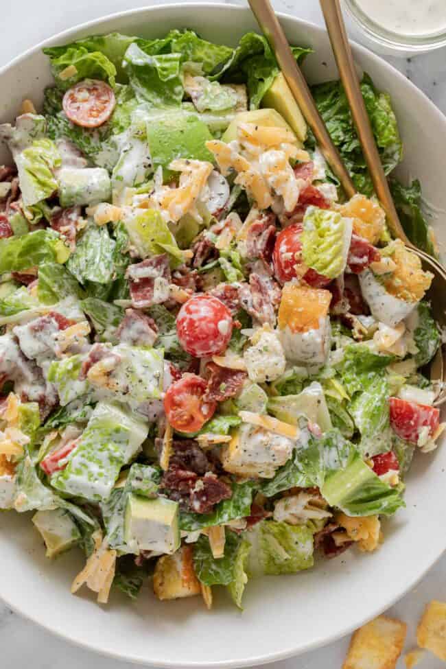A white bowl filled with BLT chopped salad tossed in dressing.