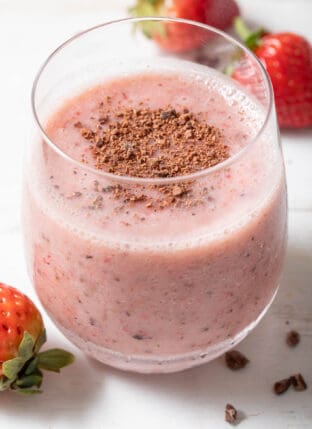 A clear drinking glass filled with Strawberry Cacao Smoothie.