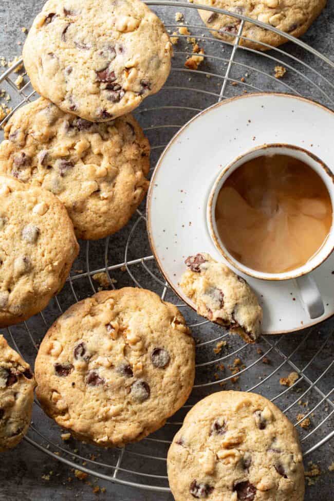 Several chocolate chip cookies on a wire cooling rack.