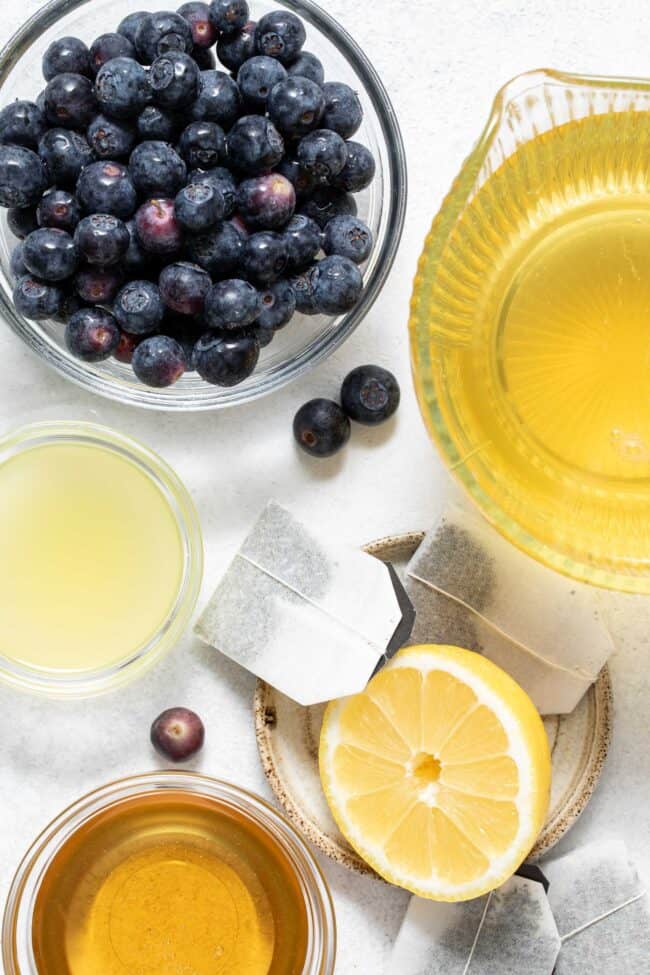 Clear mixing bowls filled with liquid, fruit, lemon juice and honey.