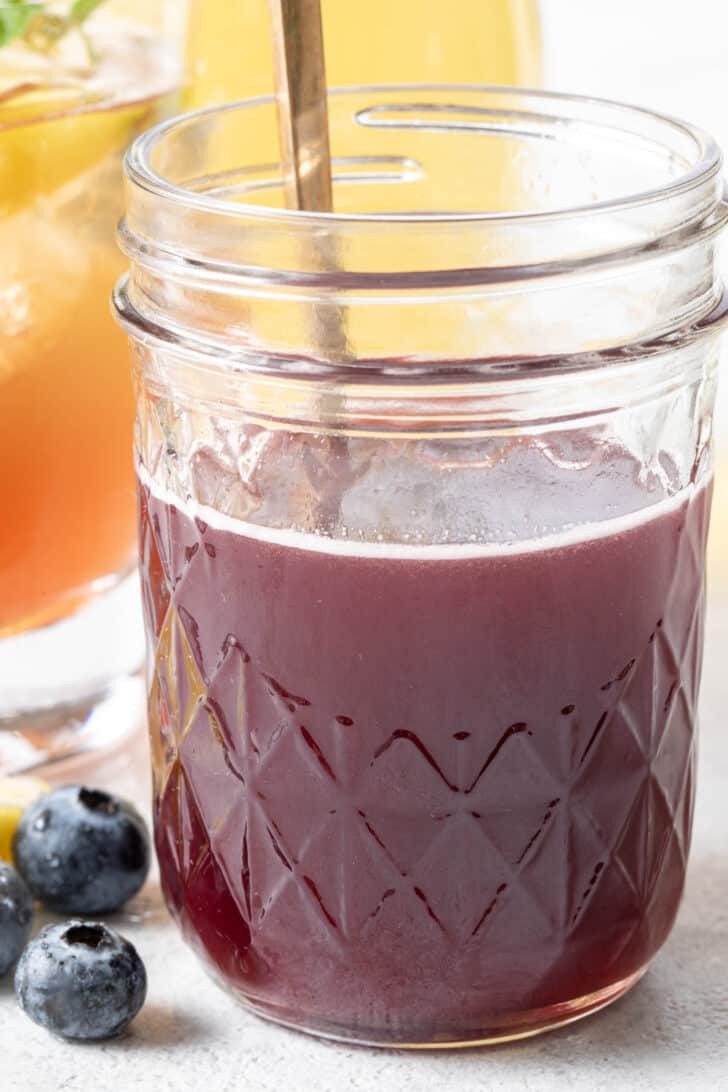 A clear mason jar filled with purple liquid. 