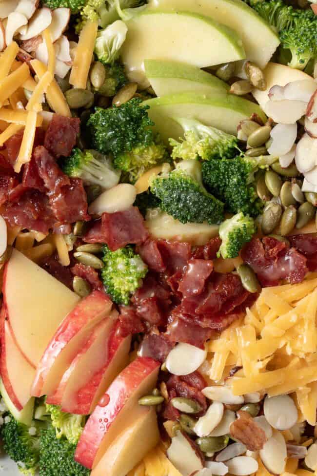 A bowl filled with chopped fruits and vegetables, nuts and seeds. 