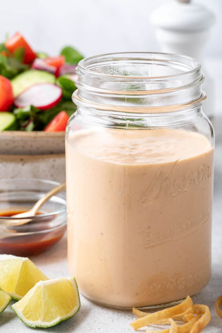 A clear glass mason jar filled with creamy sauce.