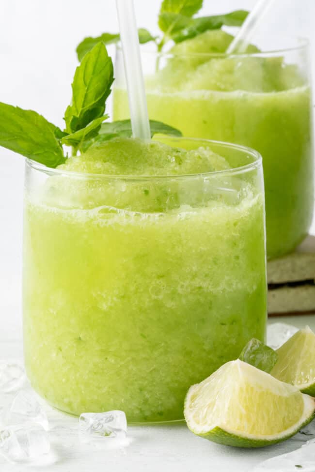 Two clear glasses filled with cucumber slushie. 