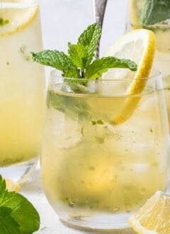 A clear glass filled with Iced Lemon Mint Green Tea.
