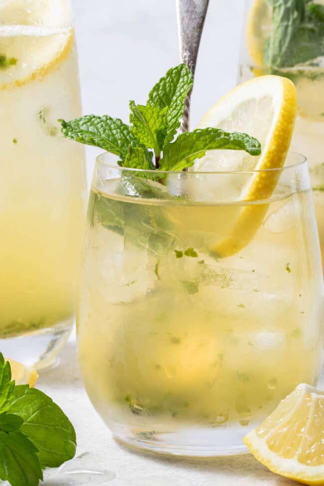 Three clear glasses filled with green tea with mint sprigs.