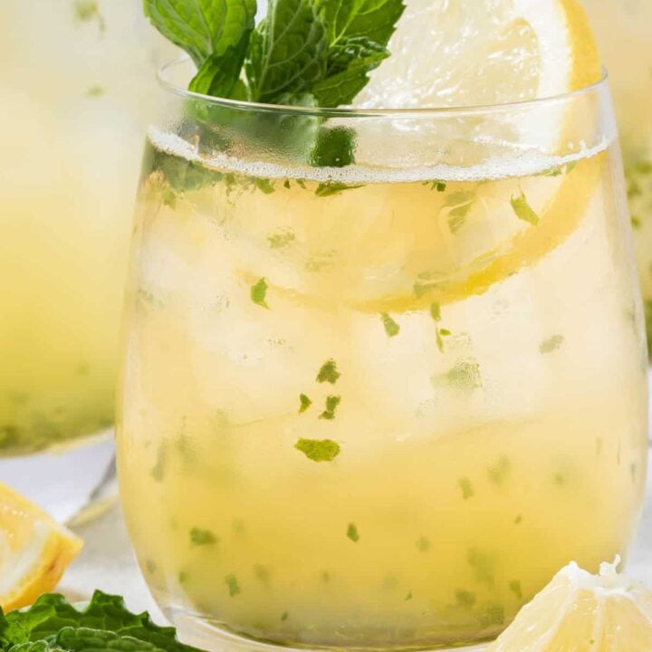 A clear glass filled with Iced Lemon Mint Green Tea.