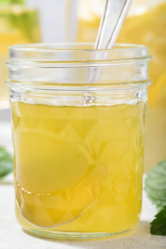 A clear glass mason jar filled with honey simple mint syrup