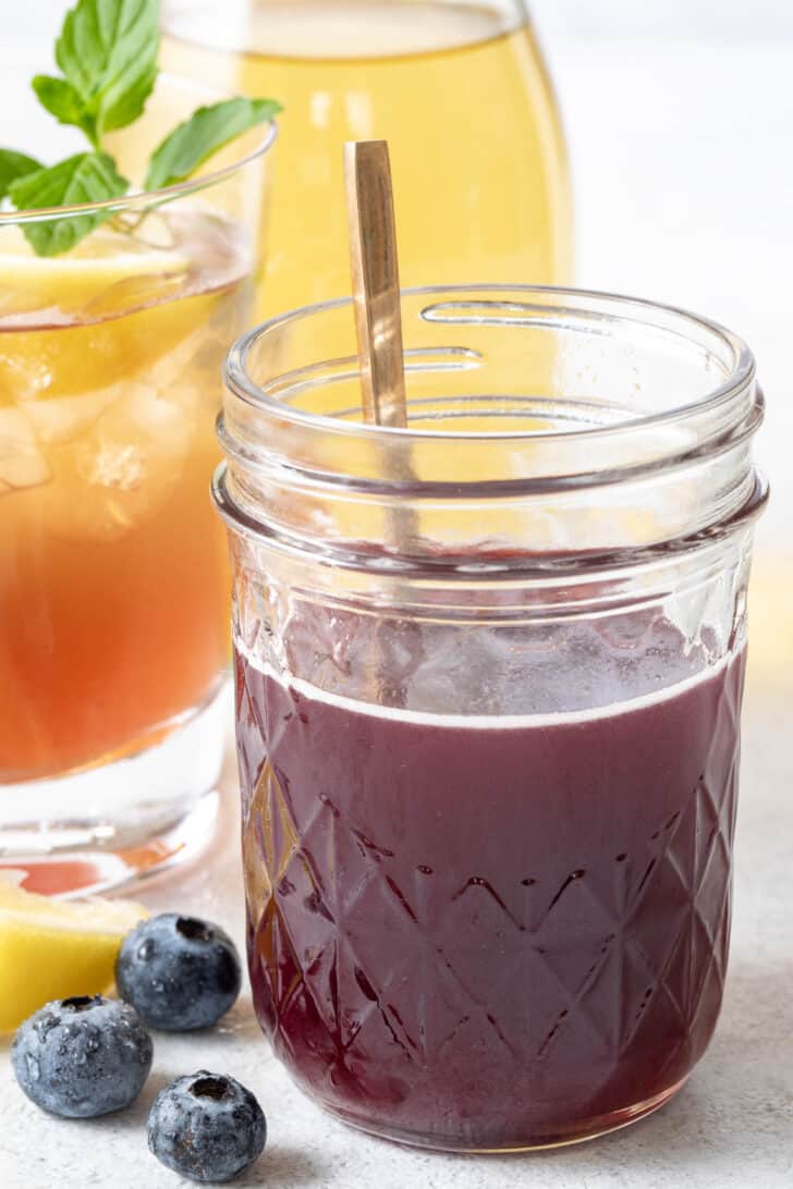 A clear glass mason jar filled with blueberry simple syrup