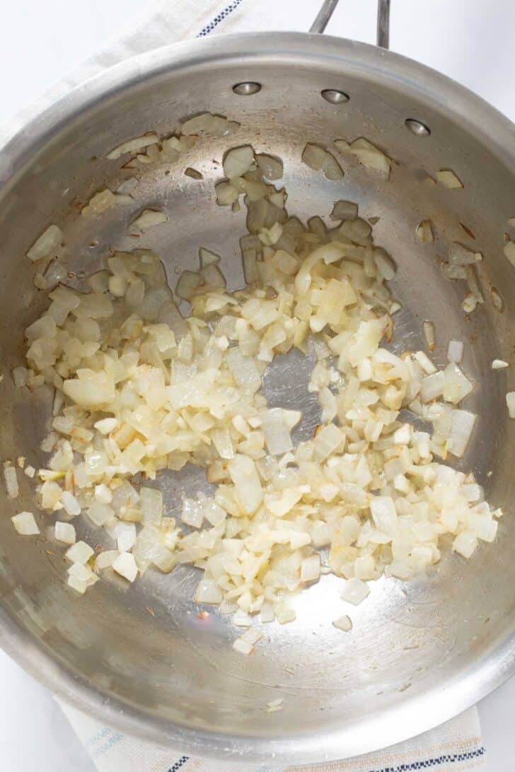 A cooking pot with sauteed onion.