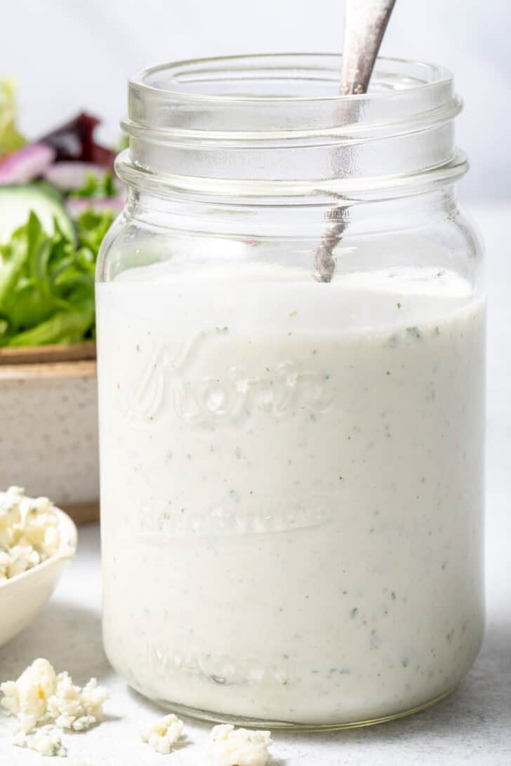 A clear mason jar filled with a creamy dip.