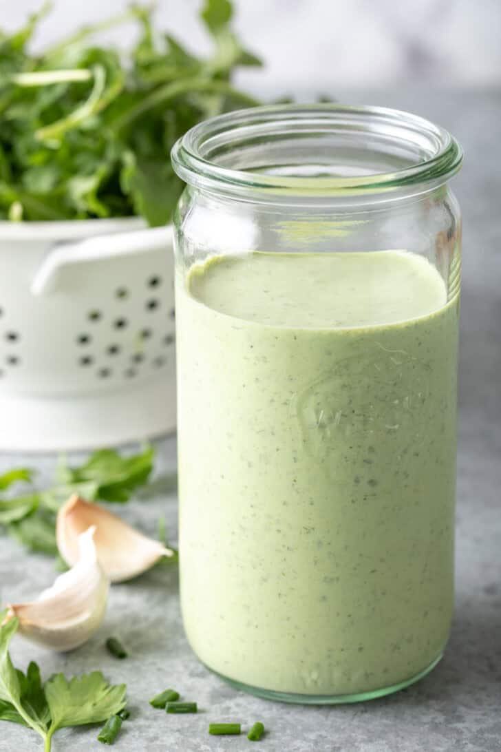 A clear glass mason jar filled with a creamy sauce.