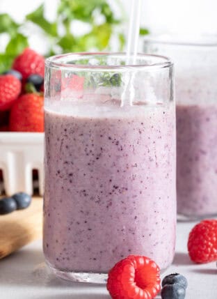 Two clear glasses filled with Mixed Berry Smoothie.