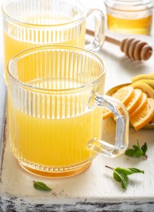Two clear tea mugs filled with Apple Cider Vinegar Tea.