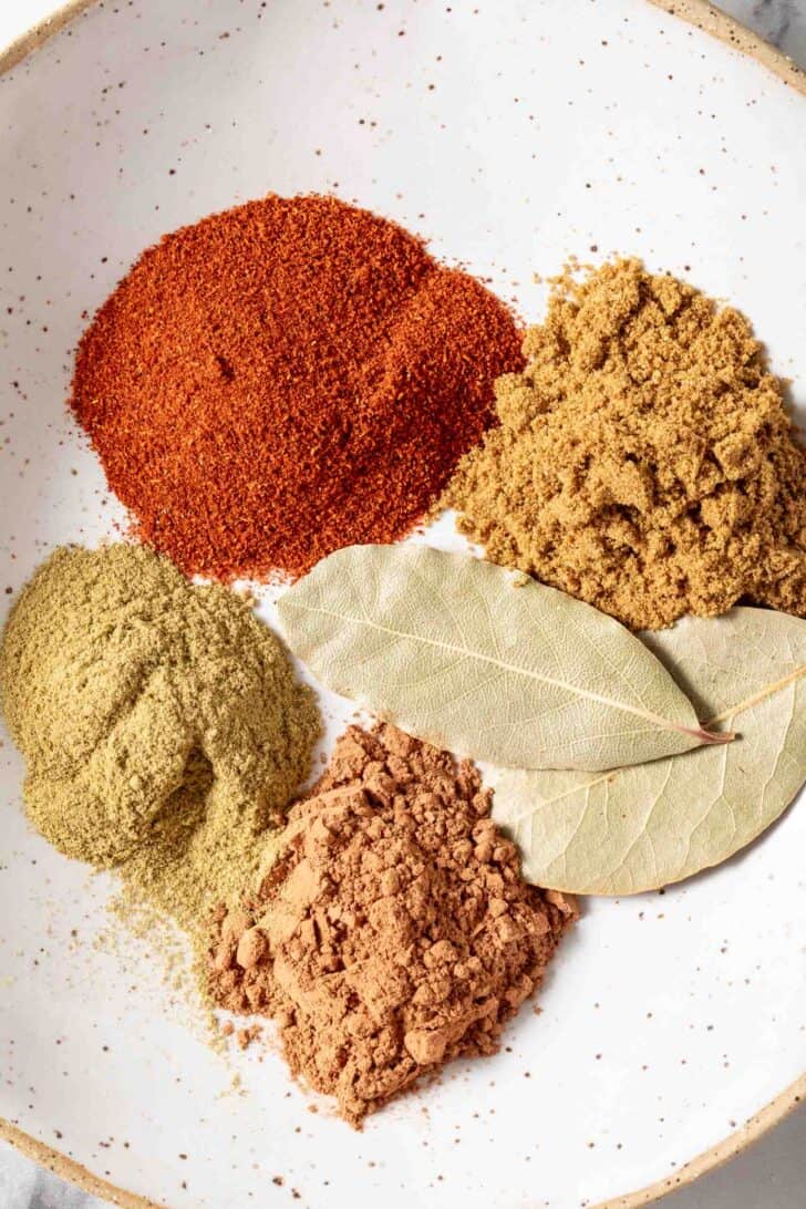 A small dish with little piles of spices to make up a homemade chili seasoning recipe.