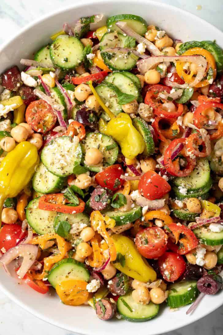 A white bowl filled with chickpea cucumber salad.