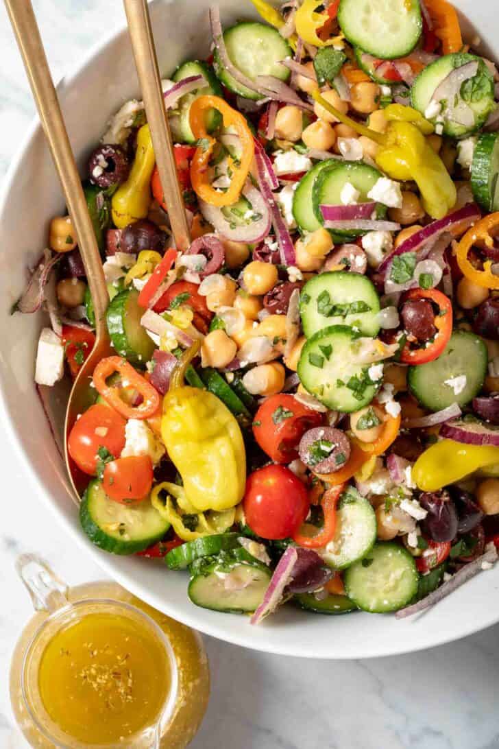 A white bowl filled with chickpea cucumber salad. 