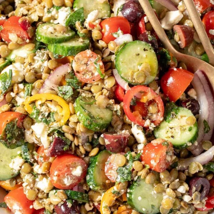 A white bowl filled with Greek Lentil Salad.