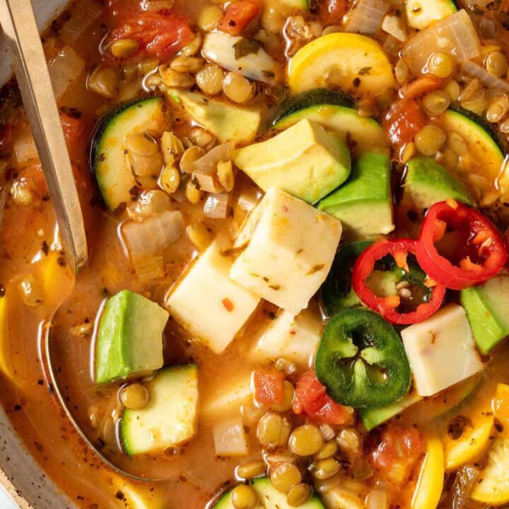 A tan colored bowl filled with Lentil Vegetable Soup.