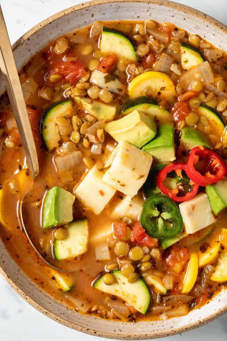 A tan bowl filled with Mexican Lentil Vegetable Soup.