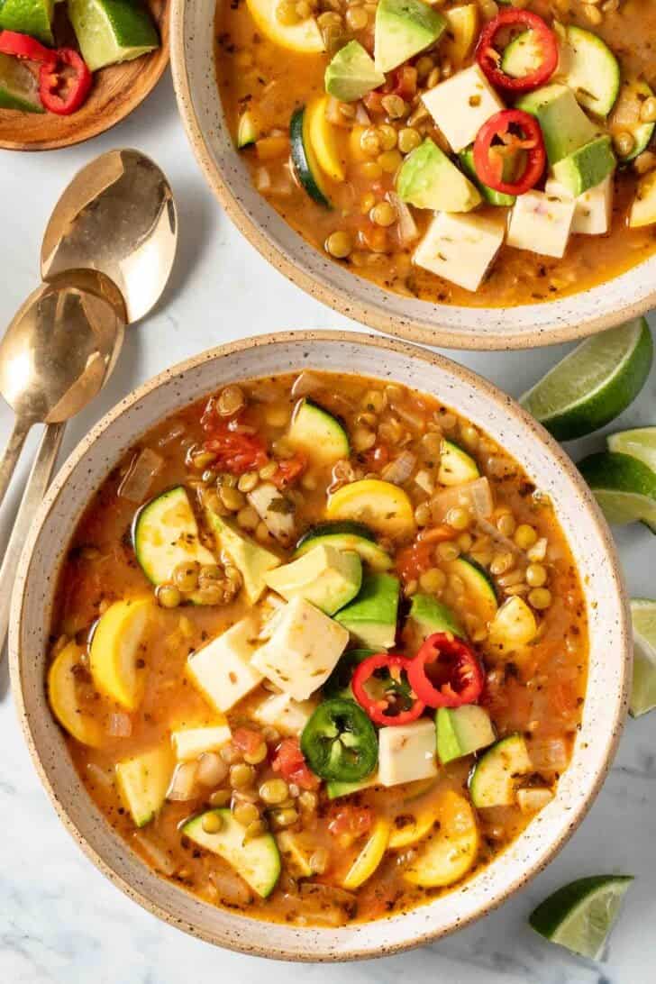 Two bowls filled with Mexican vegetable soup with lentils.