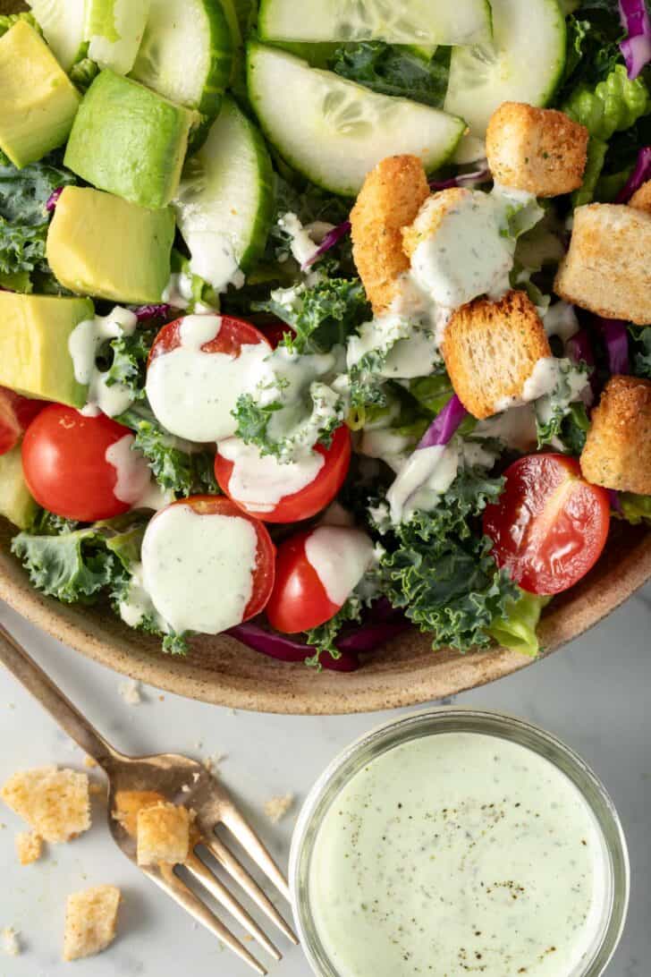 A bowl of salad tossed with Avocado Ranch Dressing.