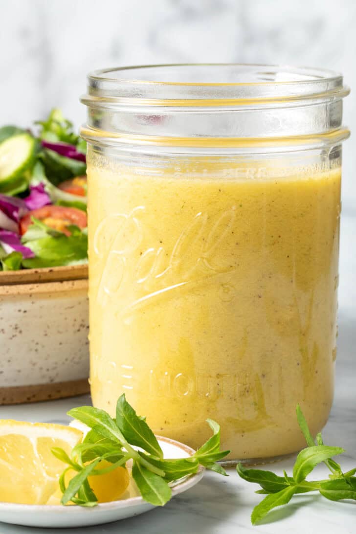 A clear glass mason jar filled with Tarragon Salad Dressing.