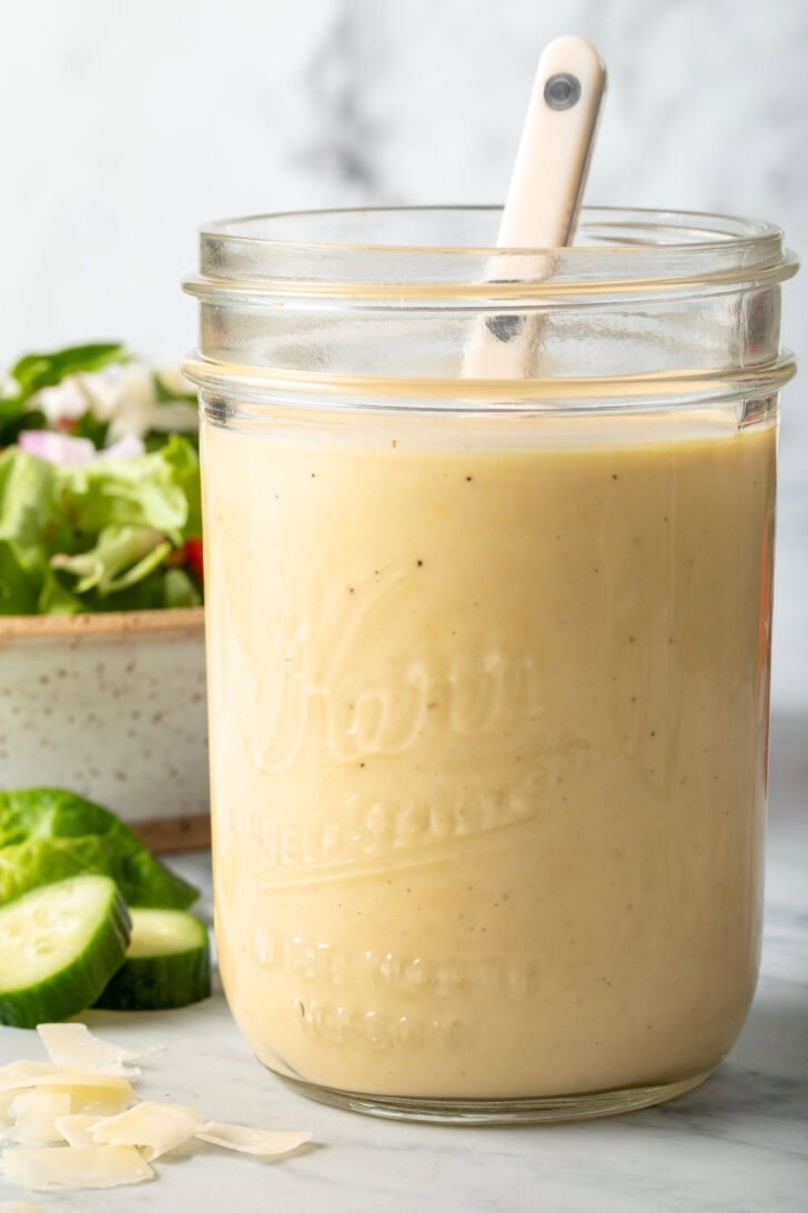 A clear mason jar filled with Dijon Mustard Vinaigrette.