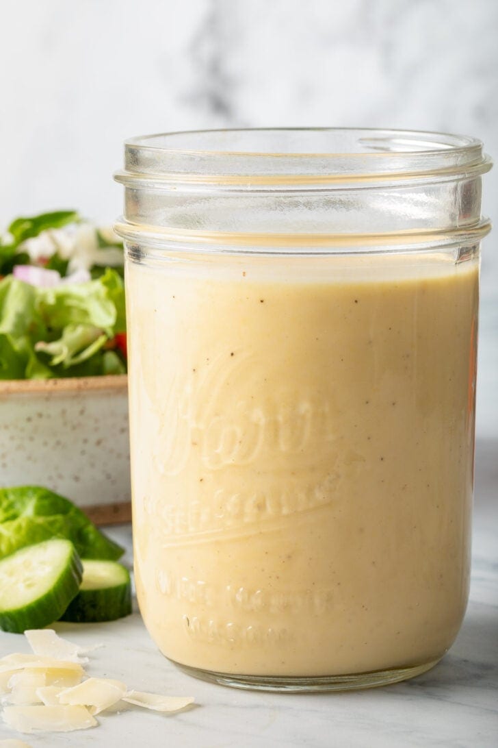 A clear mason jar filled with Mustard Vinaigrette.