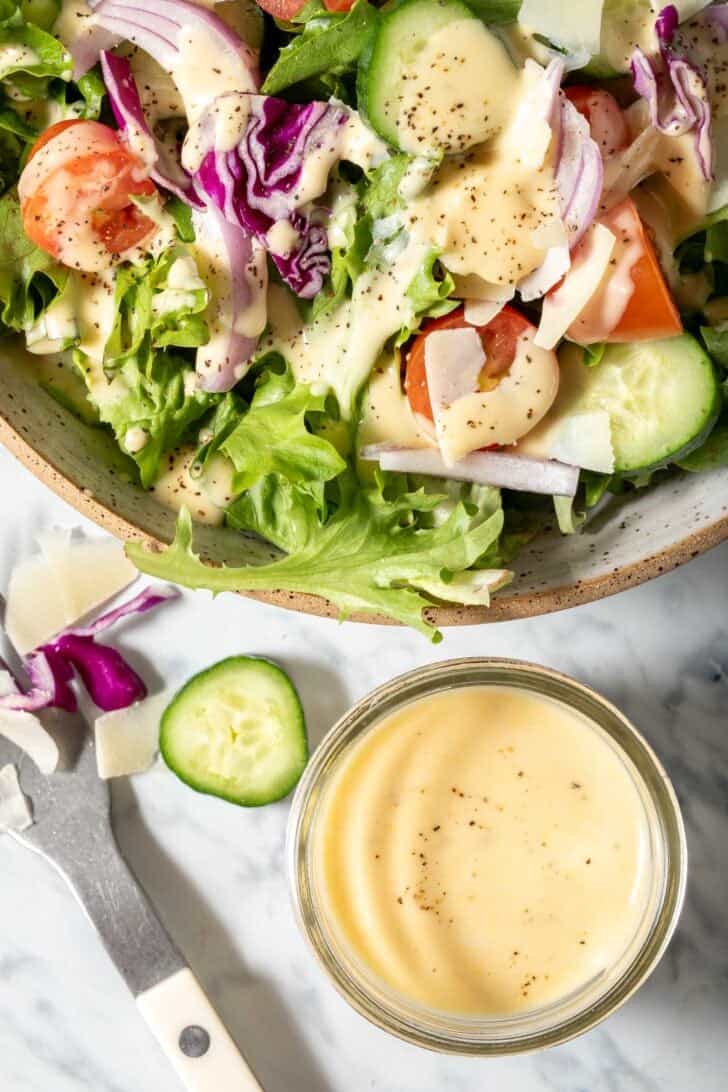 A salad bowl filled with mixed greens tossed with a Dijon Mustard Vinaigrette.