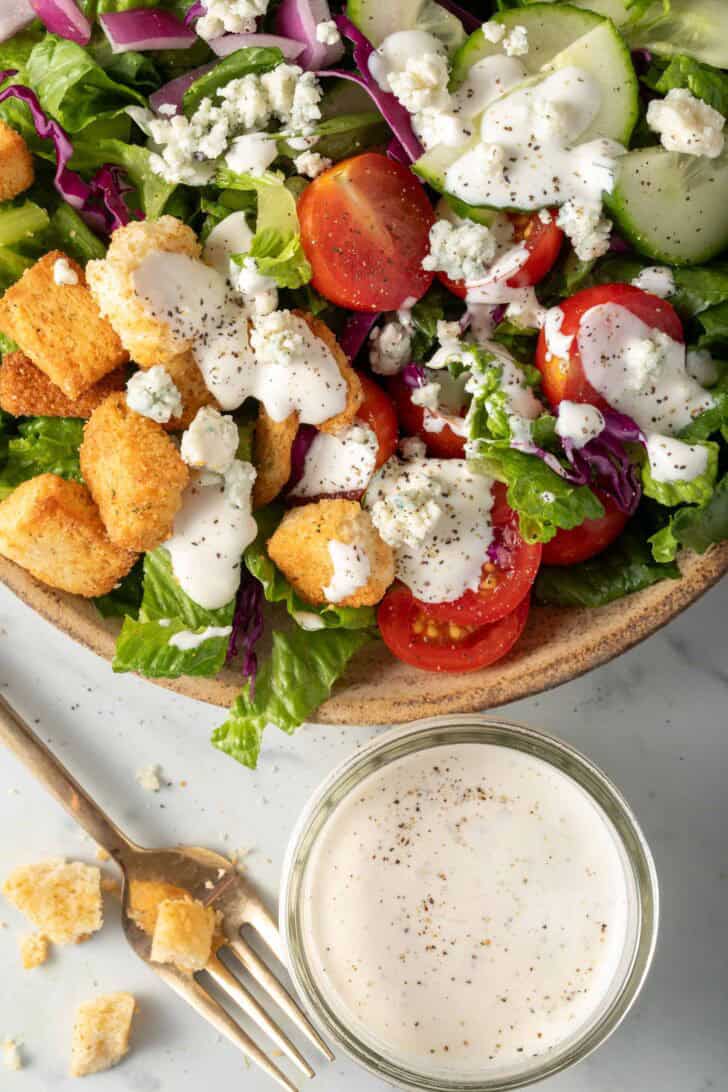 A bowl of salad tossed with Blue Cheese Dressing.