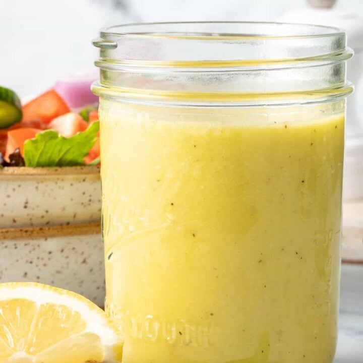 A clear mason jar filled with Lemon Vinaigrette.