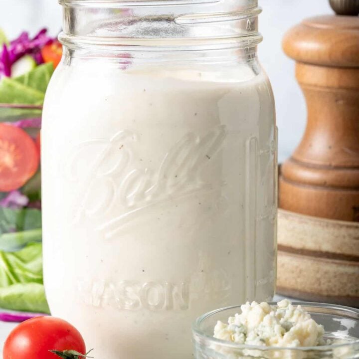 A clear mason jar filled with Homemade Blue Cheese Salad Dressing.