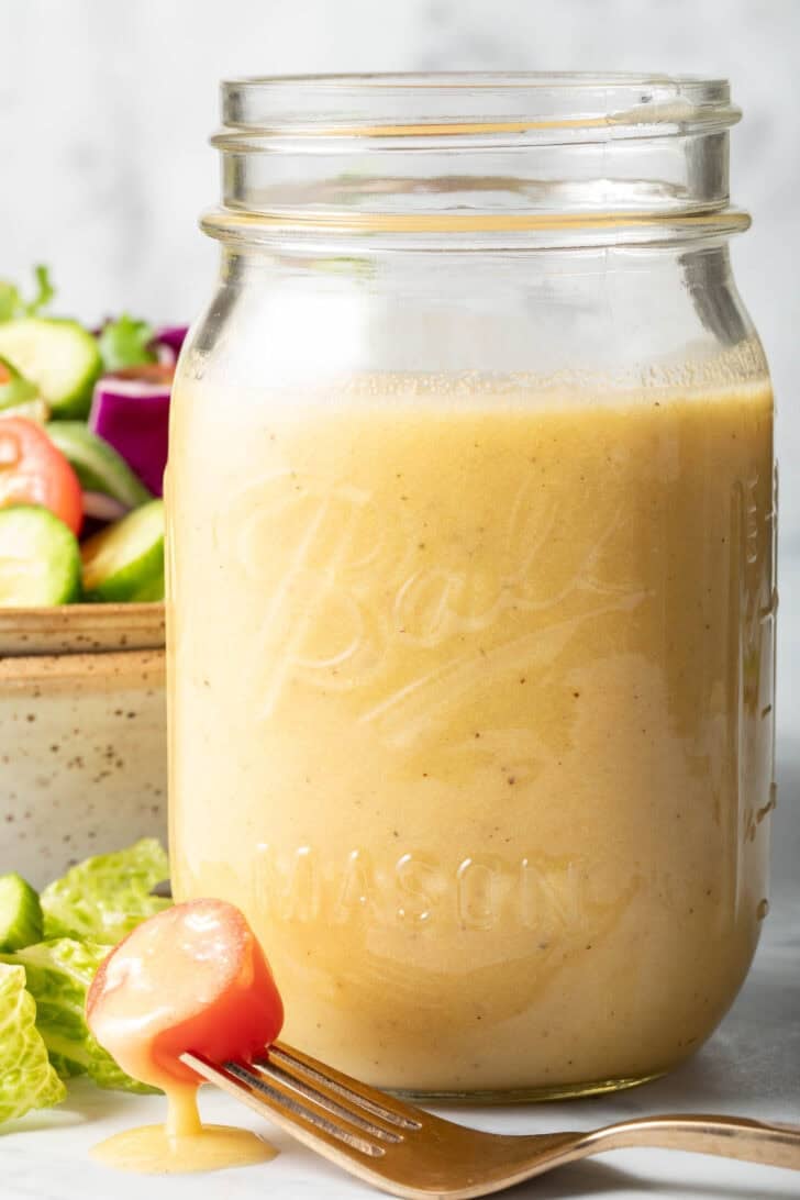 A clear glass mason jar filled with Sherry Vinaigrette.