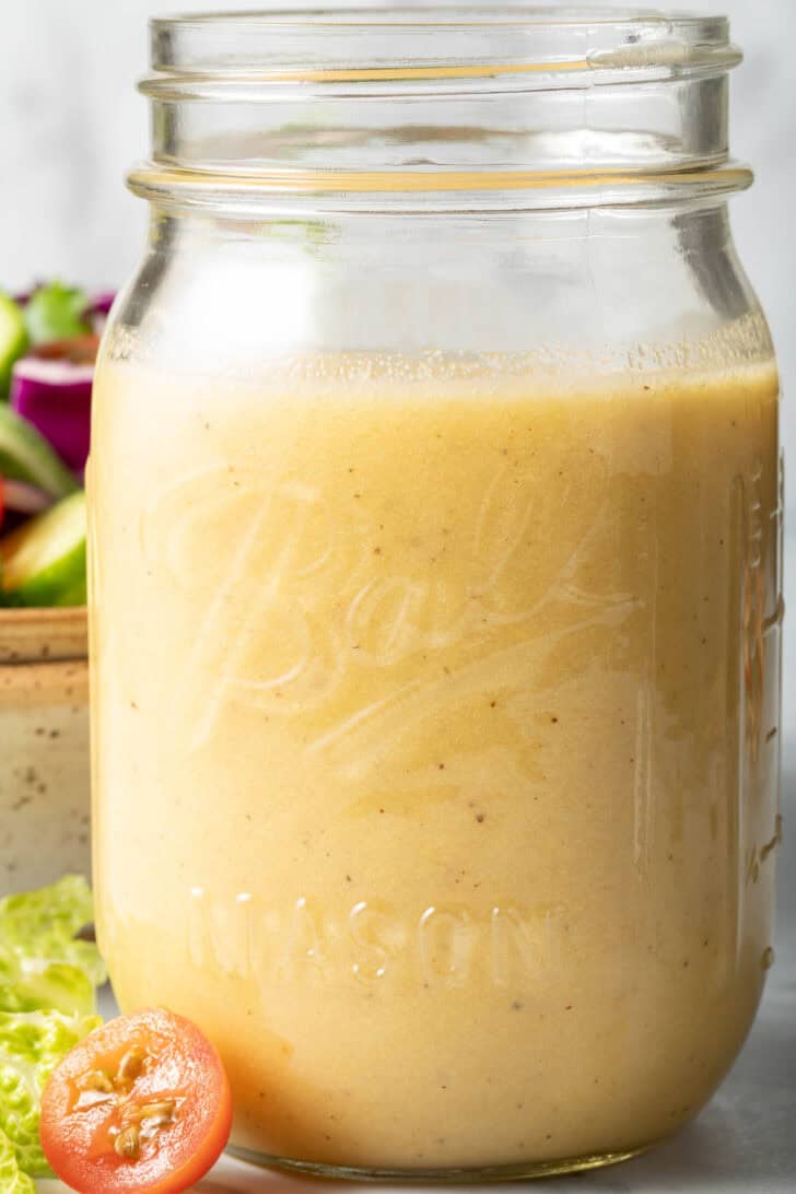 A clear mason jar filled with Sherry Dijon Vinaigrette.