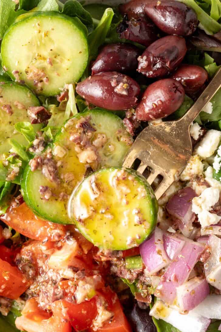 A bowl of salad tossed with Greek Vinaigrette Dressing.