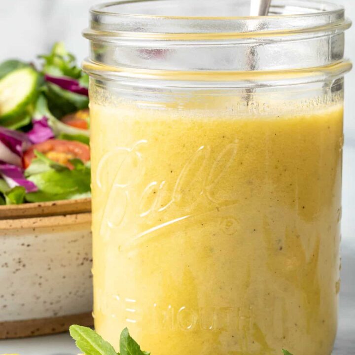 A clear mason jar filled with Tarragon Vinaigrette.