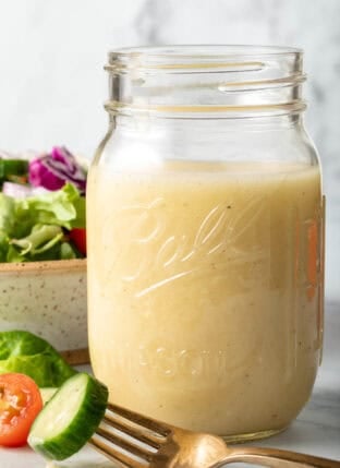 A clear glass mason jar filled with White Balsamic Vinaigrette Dressing.
