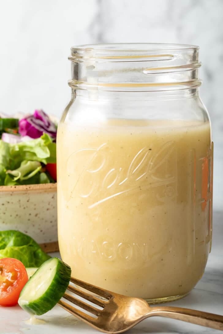 A clear glass mason jar filled with White Balsamic Vinaigrette.