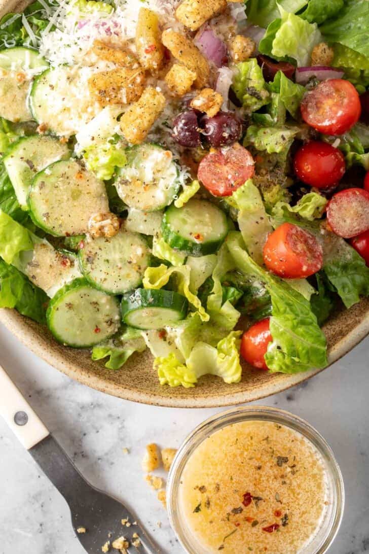 A plate filled with salad tossed with Italian Creamy Salad Dressing.