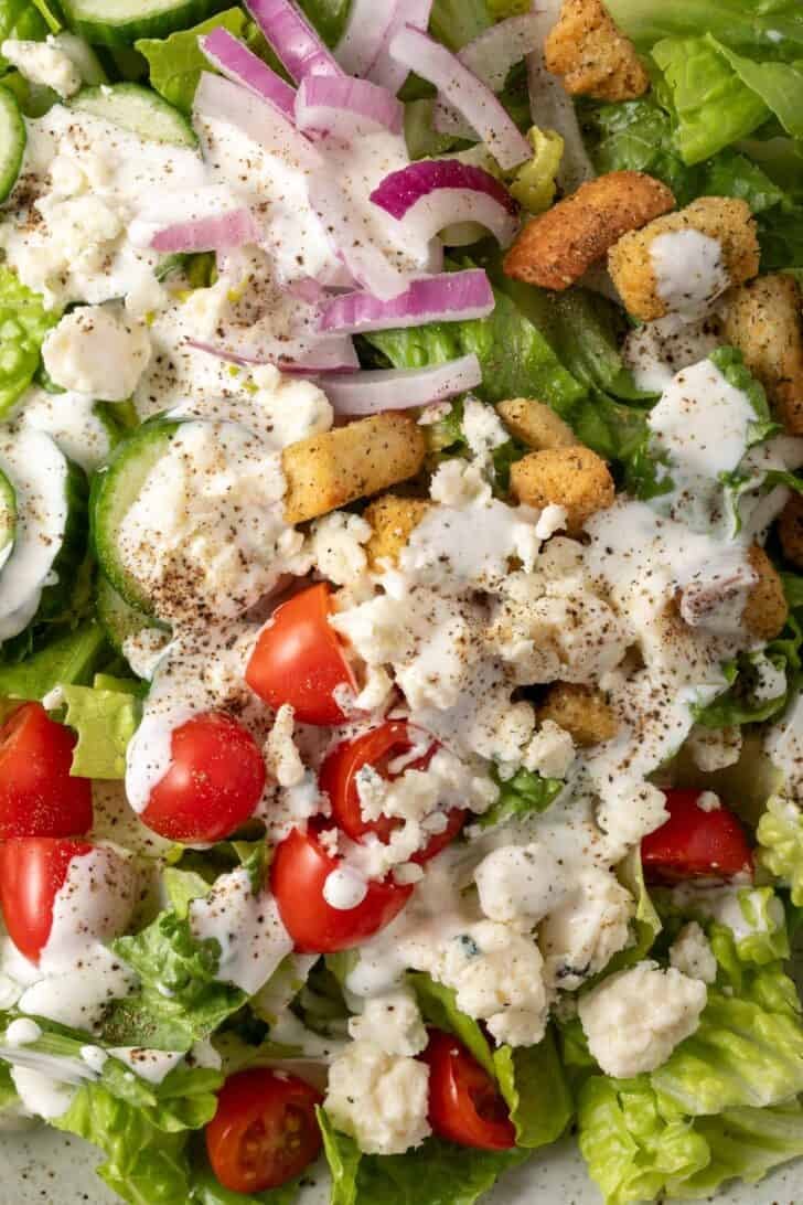 A chopped salad on a plate tossed with homemade buttermilk dressing.