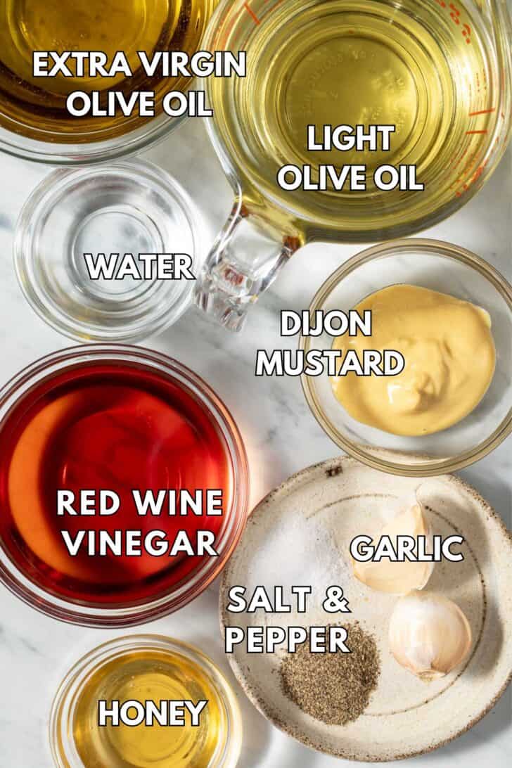 French Vinaigrette Recipe Glass bowls filled with olive oil, red wine vinegar and Dijon mustard for recipe for French vinaigrette.
