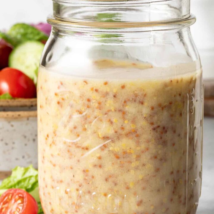 A clear mason jar filled with Honey Mustard Dressing