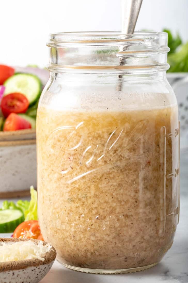 A clear mason jar filled with Creamy Italian Dressing.