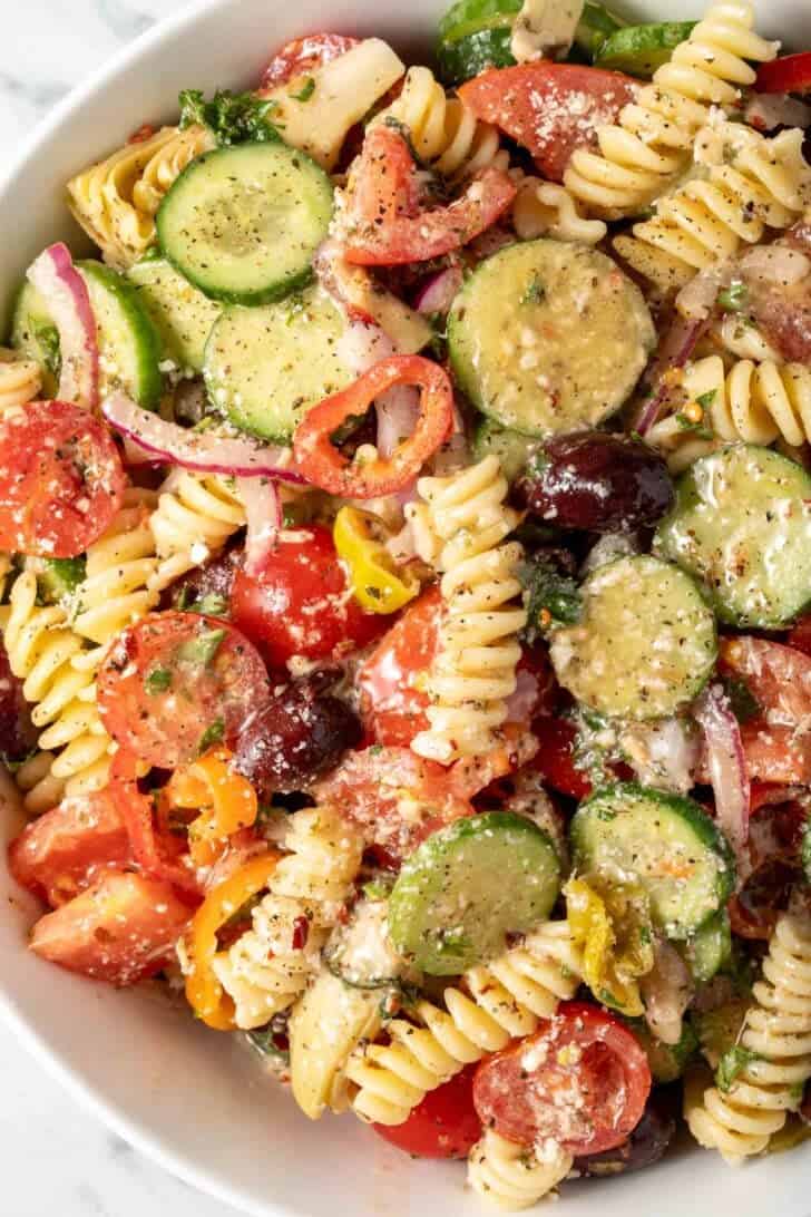 A white bowl filled with zesty Italian Pasta Salad.